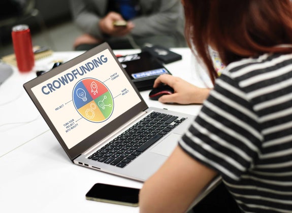 Woman using computer that shows a crowdfunding image