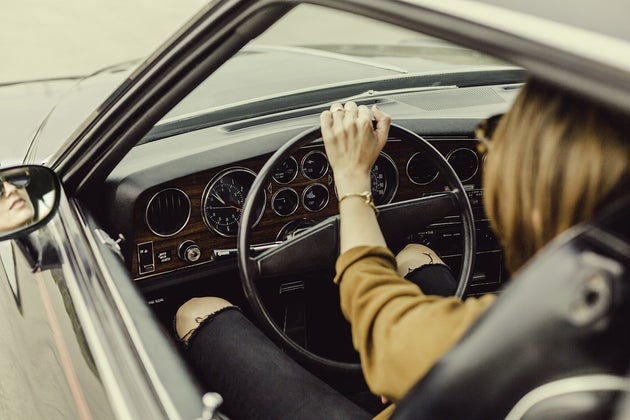 Woman driving a car on the road with the window down