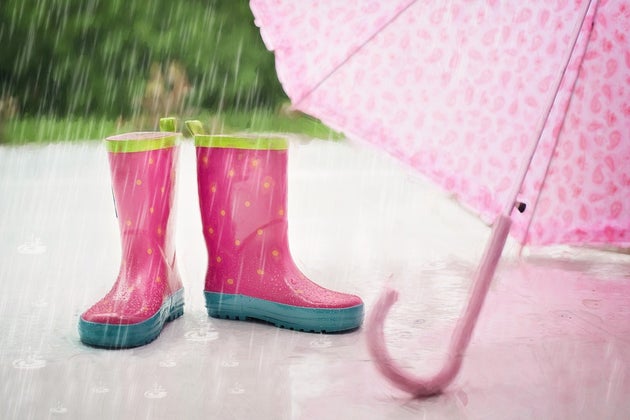 Rain boots and an umbrella sitting in the rain