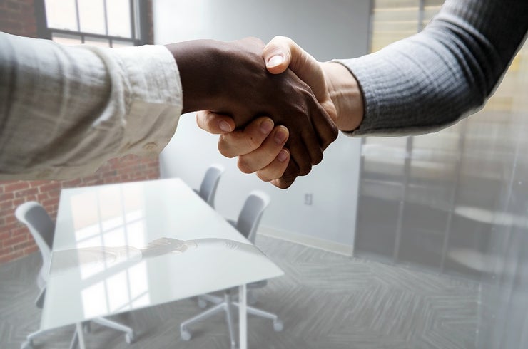 Two shaking hands in a boardroom