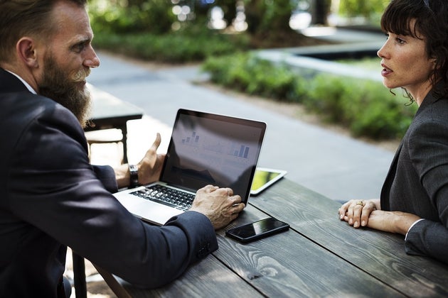 Woman and man with a laptop talking at a table