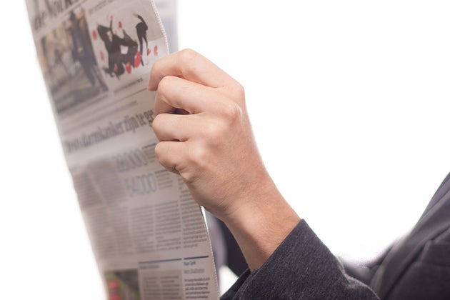 Hands holding an open newspaper